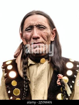 1920S PORTRÄT INDIANER CHEROKEE STAMM BLICK AUF KAMERA TRAGEN WESTE MIT SPIEGELN VERZIERT - I470C HAR001 HARS NORDAMERIKA MITTLEREN ALTERS MANN AUGENKONTAKT NORDAMERIKA KOPF UND SCHULTERN ZERKNITTERT STERN PRIDE STAMM STILVOLLE INDIANISCHE GEBÜRTIGE AMERIKANER AMERIKANER VERWITTERT CHEROKEE HAR001 INDIGENEN EINHEIMISCHEN KLEID ALTMODISCH STRENGEN STOISCHEN Stockfoto