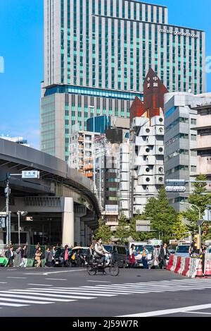 tokio, japan - oktober 28 2019: Japaner gehen auf Fußgängerüberwegen vor dem legendären Nakagin Capsule Tower Gebäude, das 70' AS errichtet wurde Stockfoto