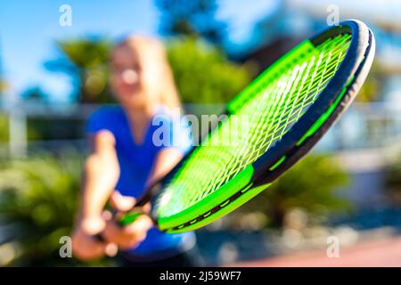 Kleiner Gürtel, der im tropischen Freien Tennis spielt Stockfoto