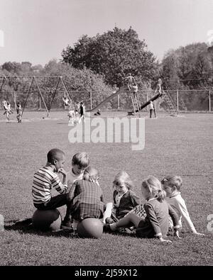 1960S 1970S VERSCHIEDENE GRUPPE VON STUDENTEN JUNGEN UND MÄDCHEN AUF GRAS SITZEN UND SPORTBÄLLE KINDER AUF SCHAUKELN UND RUTSCHE IM HINTERGRUND - J12729 HAR001 HARS KOPIEREN RAUM FREUNDSCHAFT HALBE LÄNGE PERSONEN MÄNNER B&W FREIHEIT ZIELE SCHULEN GRAD HIGH-ANGLE FREIZEIT AFROAMERIKANER AFROAMERIKANER UND NISCHE ERHOLUNG SCHWARZE ETHNIE GELEGENHEIT PRIMÄRE VERBINDUNG FREUNDLICHE UNTERSTÜTZUNG SCHWINGT ZUSAMMENARBEIT GRAD SCHULE WACHSTUM ENTSPANNUNG ZWEISAMKEIT SCHWARZ UND WEISSE KAUKASISCHE ETHNIZITÄT HAR001 ALTMODISCHE AFROAMERIKANER Stockfoto