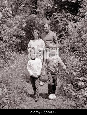 1970S MUTTER VATER UND ZWEI KINDER, DIE MIT HOHEN SOMMERBLUMEN GRAS UND UNKRAUT AUF DEM WEG SPAZIEREN - J12947 HAR001 HARS NOSTALGISCHES AKTIVES PAAR 4 MÜTTER WANDERN ALTE ZEIT NOSTALGIE BRUDER ALTE MODE SCHWESTER JUVENILE GESUNDE JUNGE ERWACHSENE SÖHNE ERFREUT FAMILIEN FREUDE LEBENSSTIL FRAUEN VERHEIRATET BRÜDER LÄNDLICHEN EHEGATTEN EHEMÄNNER GESUNDHEIT NATUR KOPIEREN RAUM FREUNDSCHAFT IN VOLLER LÄNGE HALBLANGE DAMEN TÖCHTER PERSONEN MÄNNER GESCHWISTER VERTRAUEN SCHWESTERN WANDERUNG VÄTER B&W PARTNER SOMMER BLICKKONTAKT AKTIVITÄT GLÜCK FRÖHLICH ABENTEUER FREIZEIT KRAFT VÄTER GESCHWISTER LÄCHELT VERBUNDENHEIT FLEXIBILITÄT FREUDIG Stockfoto