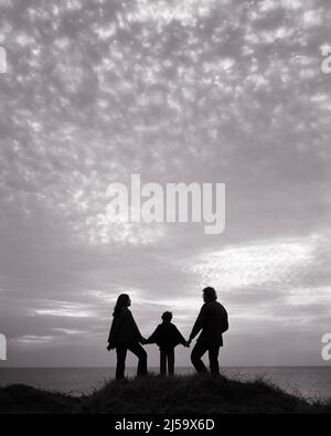 1960S 1970S ANONYME FAMILIE VON 3 MUTTER VATER KIND SILHOUETTEN IN DEN SONNENUNTERGANG AUF DER SPITZE DES HÜGELS MIT BLICK AUF DEN OZEAN - J13002 CRS001 HARS MAMA NOSTALGISCHES SYMBOL PAAR BEZIEHUNG MÜTTER ALTE ZEIT ZUKUNFT NOSTALGIE SONNENUNTERGANG ALTE MODE GRAFIK 1 JUGENDLICH JUNGE ERWACHSENE GEHEIMNIS SÖHNE ABSTRAKT FAMILIEN FREUDE LIFESTYLE OZEAN ELTERNSCHAFT FRAUEN VERHEIRATET LÄNDLICHEN EHEGATTEN EHEMÄNNER GROWNUP HÜGEL KOPIEREN RAUM MENSCHEN KINDER FREUNDSCHAFT VOLLE LÄNGE DAMEN PERSONEN INSPIRATION ERWACHSENE MÄNNER SYMBOLE SILHOUETTEN SPIRITUALITÄT VÄTER MOD B&W SKIZZIEREN PARTNER VÄTERLICHE FREIHEIT ZIELE VATERSCHAFT MÜTTERLICHE TRÄUME ABENTEUER ENTDECKUNG Stockfoto