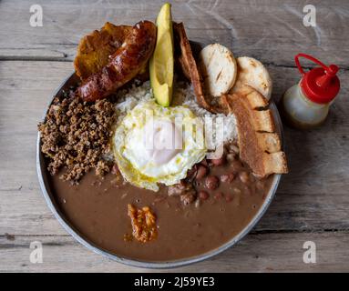 Bandeja Paisa, ein typisch kolumbianisches Gericht mit Reis, Bohnen, Kochbananen, Chorizo, Fleisch und einem Spiegelei. Kolumbien, Südamerika. Stockfoto