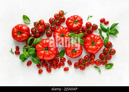 Tomaten und Basilikum auf weißem Hintergrund, Draufsicht, flach liegend Stockfoto