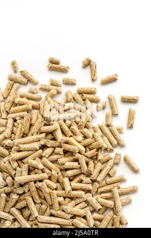 Holzpellets zum Heizen, in der Ecke eines weißen Hintergrunds platziert. Stockfoto