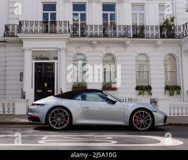 London, Greater London, England, April 09 2022: Porsche Cabriolet vor einer eleganten Immobilie in Notting Hill mit einem Herzsymbol im Fenster. Stockfoto