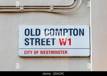 Straßennamen-Schild an einer Wand in Old Compton Street, Soho, London, Großbritannien Stockfoto