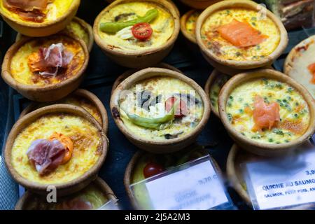 Französische Quiches im Sortiment am Marktschalter Stockfoto