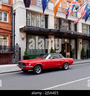 London, Greater London, England, April 09 2022: Rotes Mustang-Auto vor dem Claridges Hotel. Stockfoto