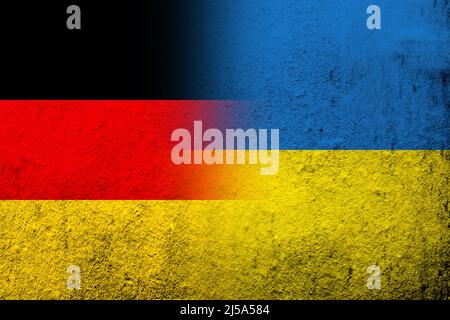 Die Nationalflagge von Deutschland mit der Nationalflagge der Ukraine. Grungen Hintergrund Stockfoto