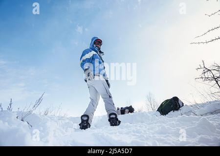 Snowboarder steht auf den Pisten des Berges mit einem Snowboard in Skiausrüstung Stockfoto