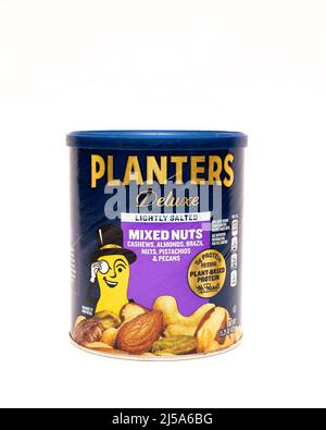 Ein Karton mit Planters Deluxe gemischten Nüssen, einschließlich Cashews, Mandeln, Paranüssen, Pekannüssen und Pistazien isoliert auf Weiß Stockfoto