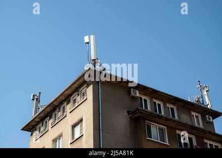 GSM-Mobilfunkantenne Turm auf Hausdach Stockfoto