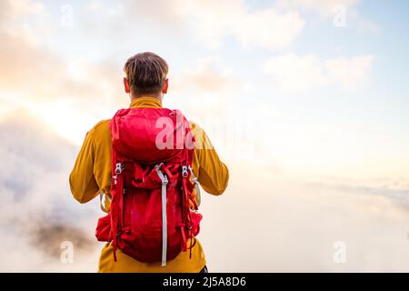 Junger, fröhlicher Fotograf, der mit einer Vintage-Kamera der alten Schule in einem Gebirge fotografiert Stockfoto