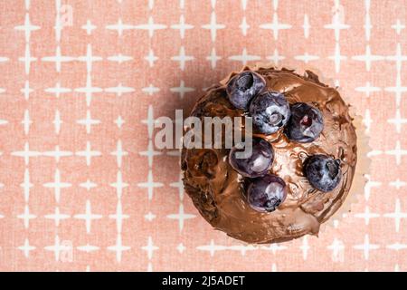Frisch gebackene Muffins mit Schokoladencreme und Heidelbeeren auf dem Tisch Platz zum Kopieren Stockfoto