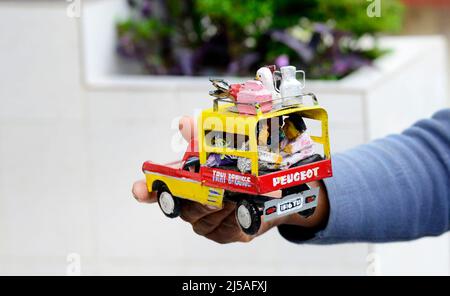 Eine madagassische Frau, die handgemachtes Autospielzeug in Antananarivo, Madagaskar verkauft. Stockfoto