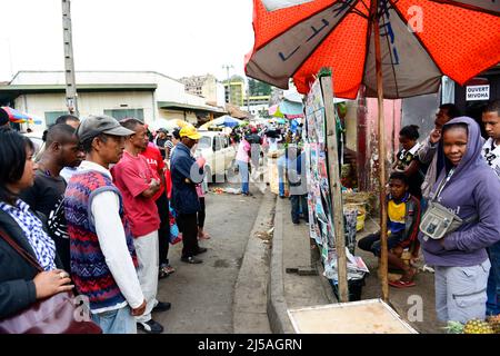 Madagassische Männer und Frauen lesen vor den Parlamentswahlen im Dezember 2013 die Morgenzeitungen an einem Zeitungsstand. Antananarivo, Madagaskar. Stockfoto