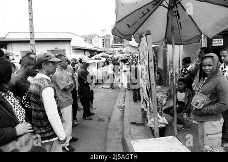 Madagassische Männer und Frauen lesen vor den Parlamentswahlen im Dezember 2013 die Morgenzeitungen an einem Zeitungsstand. Antananarivo, Madagaskar. Stockfoto