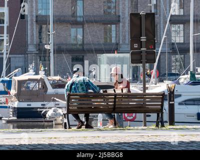 Antwerpen, Belgien, 17. April 2020, das Paar sitzt auf einer Bank am Kai am Willemdock in Antwerpen Stockfoto