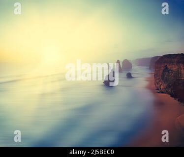 Der Sonnenuntergang über den 12 Aposteln, in der Nähe von Port Campbell, Shipwreck Coast, Great Ocean Road, Victoria, Australien Stockfoto