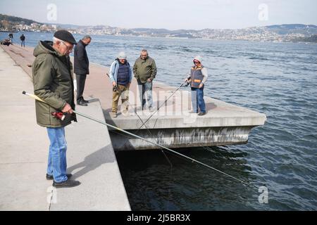 Istanbul, Türkei. 21. April 2022. Am Ufer der Bosporusstraße in Istanbul, Türkei, fischen Menschen, 21. April 2022. Quelle: Shadati/Xinhua/Alamy Live News Stockfoto