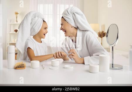 Glückliche Mutter und ihre kleine Tochter haben Spaß zusammen genießen Morgen Schönheit Routine. Stockfoto