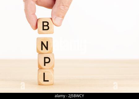 BNPL-Botschaft auf Holzblöcken. Jetzt kaufen später bezahlen Konzept. Speicherplatz kopieren Stockfoto