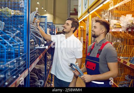 Verkaufsassistent im Baumarkt hilft dem Kunden bei der Auswahl eines neuen Schlauchs für die Waschmaschine Stockfoto