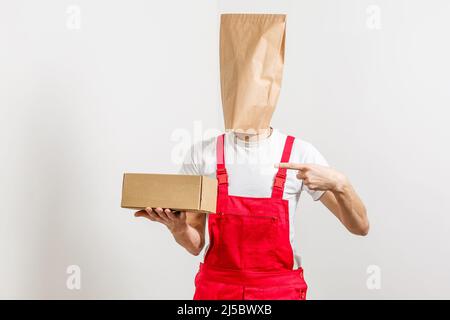 Mann mit Lebensmittelpaket mit Paketen auf dem Kopf Stockfoto