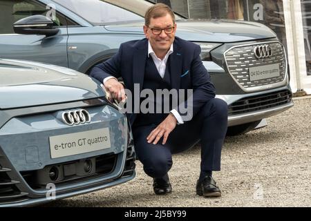 Gmund Am Tegernsee, Deutschland. 22. April 2022. Markus Duesmann, Vorstandsvorsitzender der Audi AG, stellt sich neben einem Audi e-tron GT Quadro am Rande des „Ludwig Erhard Summit“. An dem zweitägigen Gipfel nehmen Vertreter aus Wirtschaft, Politik, Wissenschaft und Medien Teil. Kredit: Peter Kneffel/dpa/Alamy Live Nachrichten Stockfoto