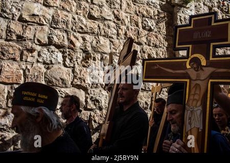 Jerusalem, Israel. 22. April 2022. Orthodoxe Christen tragen Holzkreuze, während sie während der Karfreitagsprozession in der Altstadt von Jerusalem entlang der Via Dolorosa (Weg des Leidens) gehen. Quelle: Ilia Yefimovich/dpa/Alamy Live News Stockfoto