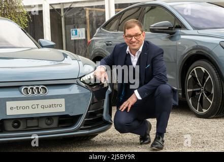 Gmund Am Tegernsee, Deutschland. 22. April 2022. Markus Duesmann, Vorstandsvorsitzender der Audi AG, stellt sich neben einem Audi e-tron GT Quattro am Rande des 'Ludwig Erhard Summit'. An dem zweitägigen Gipfel nehmen Vertreter aus Wirtschaft, Politik, Wissenschaft und Medien Teil. Kredit: Peter Kneffel/dpa/Alamy Live Nachrichten Stockfoto