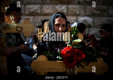 Jerusalem, Israel. 22. April 2022. Orthodoxe Christen tragen Holzkreuze, während sie während der Karfreitagsprozession in der Altstadt von Jerusalem entlang der Via Dolorosa (Weg des Leidens) gehen. Quelle: Ilia Yefimovich/dpa/Alamy Live News Stockfoto