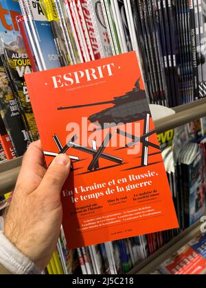 Paris, Frankreich - 11. Apr 2022: Mann kauft am Pressekioské Esprit Zeitungsmagazin mit Tank auf dem Hauptcover - russische Invasion in der Ukraine Hauptschlagzeile Stockfoto