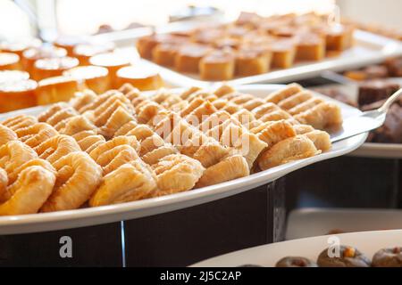 Baklava - ist ein mehrschichtiges Gebäck Dessert aus Filoteig, gefüllt mit gehackten Nüssen und gesüßt mit Sirup oder Honig. Desserttisch in einem türkischen heißen Stockfoto