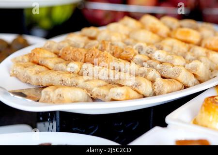 Baklava - ist ein mehrschichtiges Gebäck Dessert aus Filoteig, gefüllt mit gehackten Nüssen und gesüßt mit Sirup oder Honig. Desserttisch in einem türkischen heißen Stockfoto