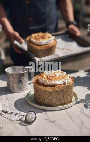 Traditioneller russischer und ukrainischer kulich kulich gefüllt mit Kondensmilch, frisch gebacken. Konditor im Hintergrund. Stockfoto