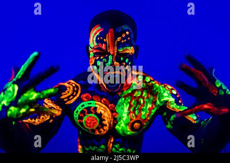afroamerikanischer Mann posiert im Studio mit UV-Licht Stockfoto
