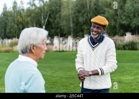 Lächelnder afroamerikanischer Mann, der einen älteren asiatischen Freund ansieht Stockfoto