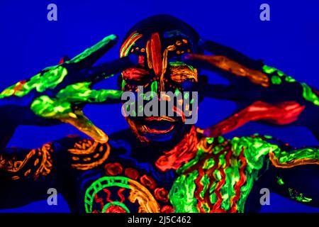 afroamerikanischer Mann posiert im Studio mit UV-Licht Stockfoto