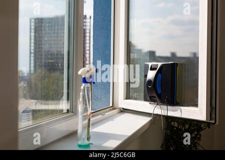 Detail eines Glasreinigungsroboters, der hinter einem Fenster agiert Stockfoto