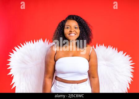 spanien fröhlicher Engel mit Flügeln auf rotem Hintergrund Studio Stockfoto