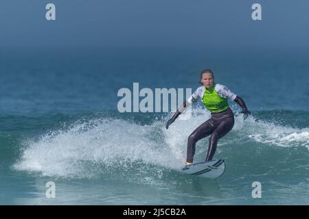 Eine Surferin, die an einem Surfwettbewerb im britischen Fistral in Newquay in Cornwall teilhat. Stockfoto