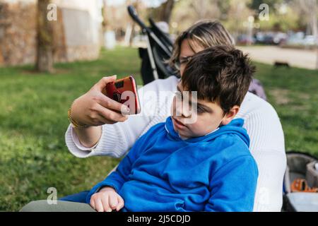 Eine Mutter, die mit ihrem Sohn, der im Park behindert ist, ein Selfie gemacht hat Stockfoto