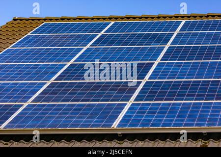Solarzellen einer privaten Photovoltaikanlage auf einem Dach in Deutschland ermöglichen die Energiewende Stockfoto