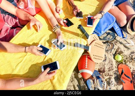 Gruppe multirassischer Freunde, die zusammen mit dem Smartphone Spaß haben - Nahaufnahme gemischter Hände Social Networking mit Handy an sonnigen Tagen - Tec Stockfoto