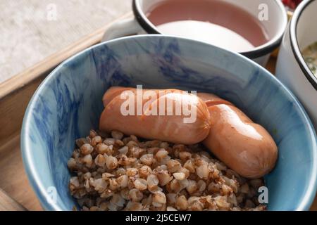 Gesunde Garnierung von Buchweizen und veganen Würsten in einer Schüssel. Mittagessen, zweiter Gang. Stockfoto