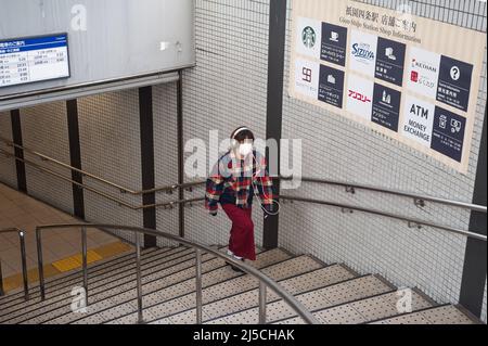 23. Dezember 2017, Kyoto, Japan, Asien - Eine junge Frau mit Mundschutz und Kopfhörern geht eine Treppe in einer U-Bahnstation in der Innenstadt hinauf. [Automatisierte Übersetzung] Stockfoto