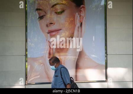 28. Mai 2020, Singapur, Republik Singapur, Asien - Ein Mann geht während der Ausgangssperre an einer Plakatwand vorbei, während er einen Mundschutz trägt, um sich vor dem pandemischen Coronavirus (Covid-19) zu schützen, kurz vor der ersten Phase der Ausgangssperre und der Wiedereröffnung. [Automatisierte Übersetzung] Stockfoto