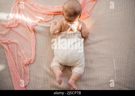 Das Baby lernt, seinen Kopf zu halten und auf meinem Bauch zu Rollen. Die Vorteile des Liegen auf dem Bauch für die motorische Entwicklung Stockfoto